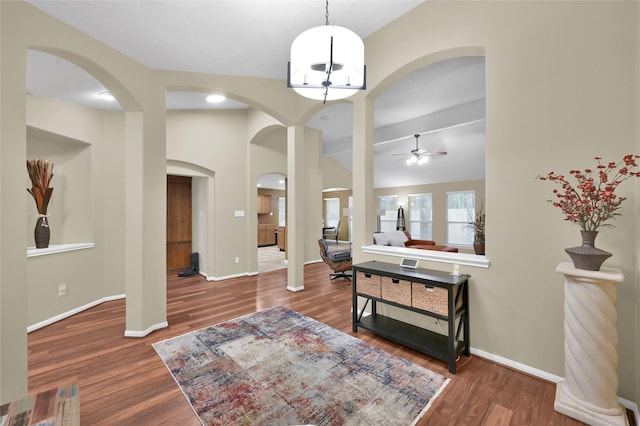 foyer entrance featuring ceiling fan, baseboards, wood finished floors, and vaulted ceiling