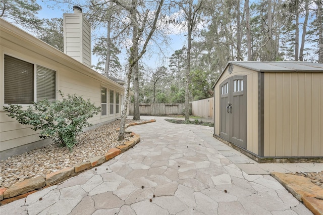 view of patio / terrace featuring a storage shed, an outbuilding, and a fenced backyard