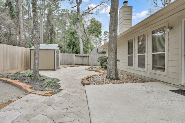 view of patio featuring an outbuilding, a storage unit, and a fenced backyard