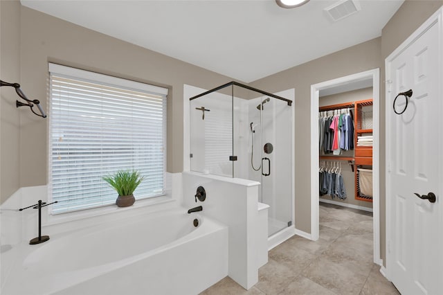 bathroom featuring a stall shower, visible vents, a bath, and a spacious closet