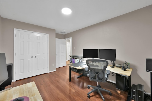 office area with visible vents, baseboards, and wood finished floors