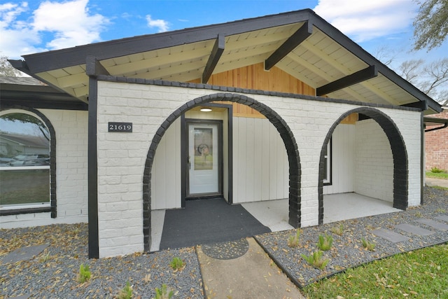 doorway to property featuring brick siding