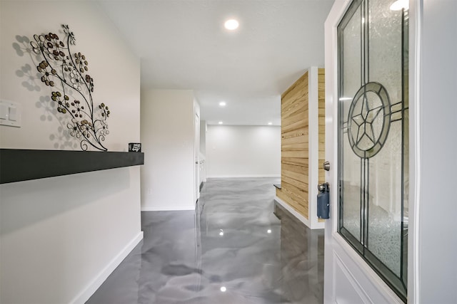 hall with recessed lighting, concrete flooring, and baseboards