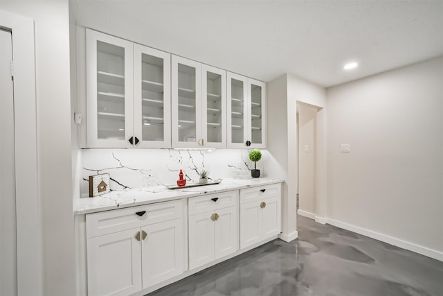 bar featuring recessed lighting, concrete flooring, and baseboards