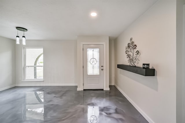 entryway with baseboards and concrete flooring