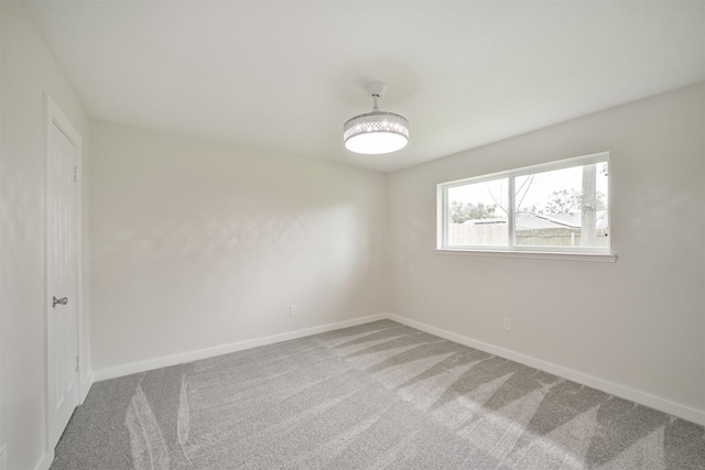 carpeted spare room with baseboards