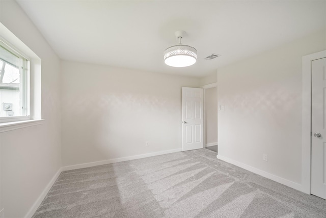 carpeted empty room featuring visible vents and baseboards