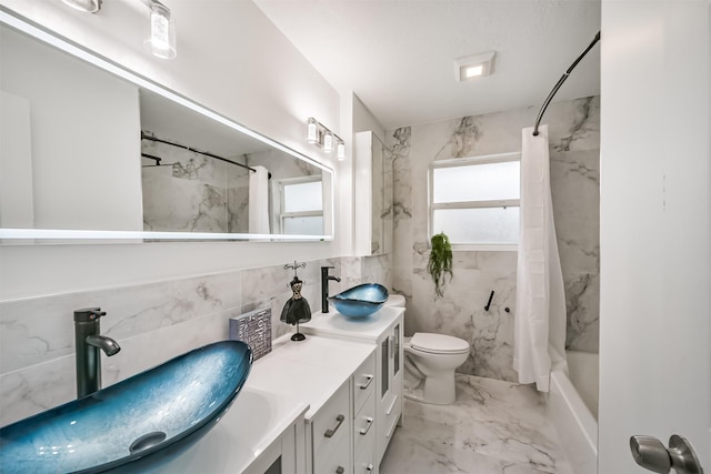 bathroom with double vanity, marble finish floor, toilet, and a sink