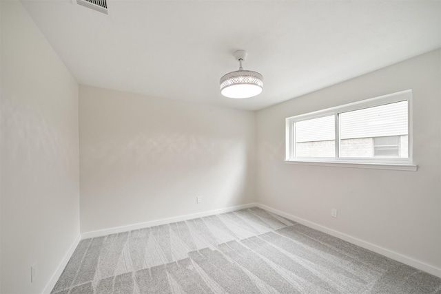 carpeted empty room with visible vents and baseboards