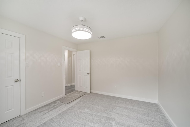 empty room featuring carpet, visible vents, and baseboards