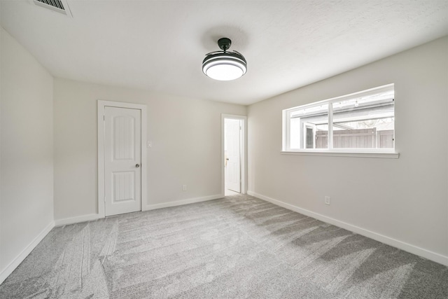 unfurnished room featuring visible vents, carpet flooring, and baseboards