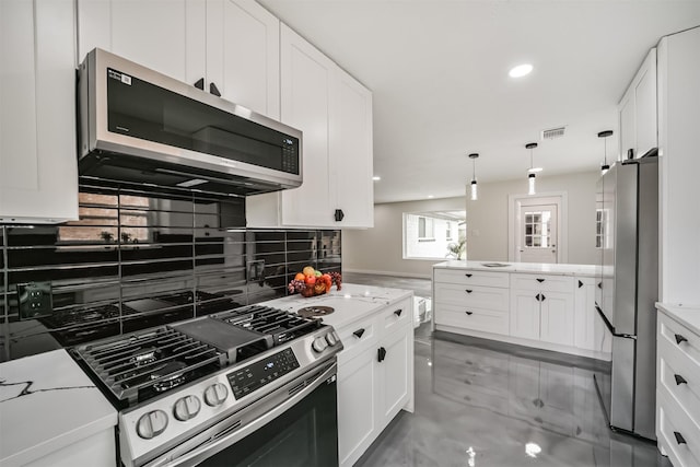 kitchen featuring visible vents, pendant lighting, backsplash, stainless steel appliances, and white cabinets