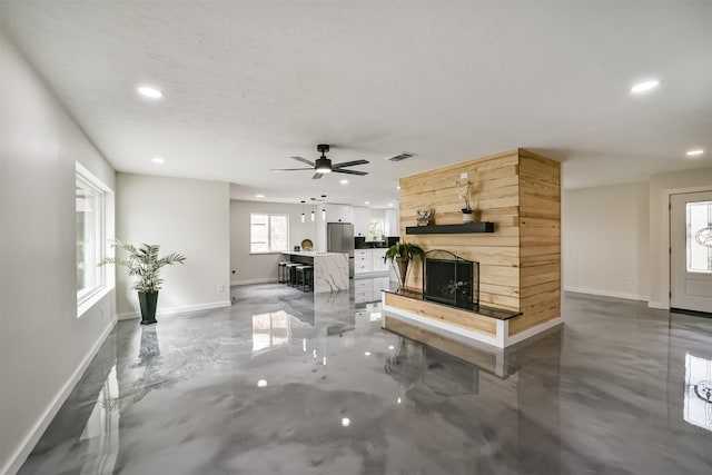 unfurnished living room featuring recessed lighting, visible vents, a fireplace with raised hearth, and baseboards