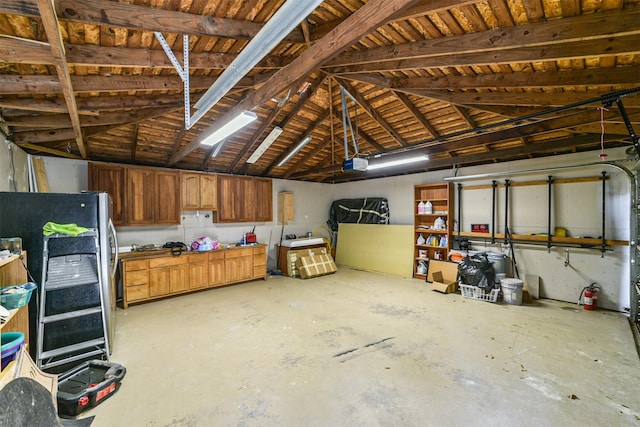 garage with a garage door opener and freestanding refrigerator