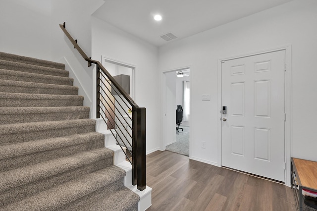 foyer featuring visible vents, baseboards, dark wood finished floors, stairway, and recessed lighting