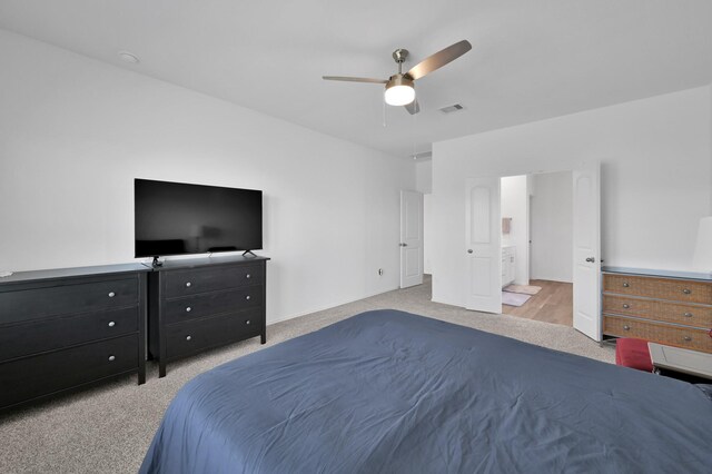 carpeted bedroom featuring visible vents and a ceiling fan