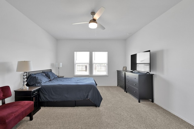 bedroom with light carpet, ceiling fan, and baseboards