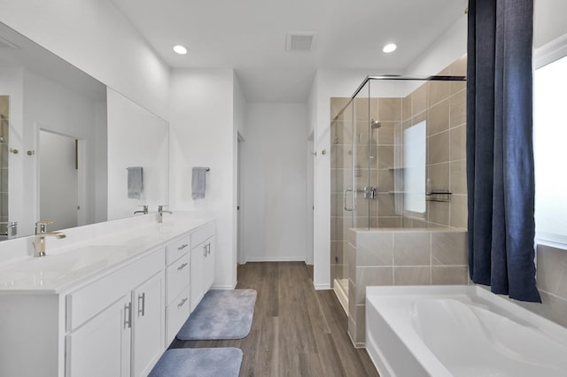 bathroom featuring a bath, visible vents, a stall shower, and a sink