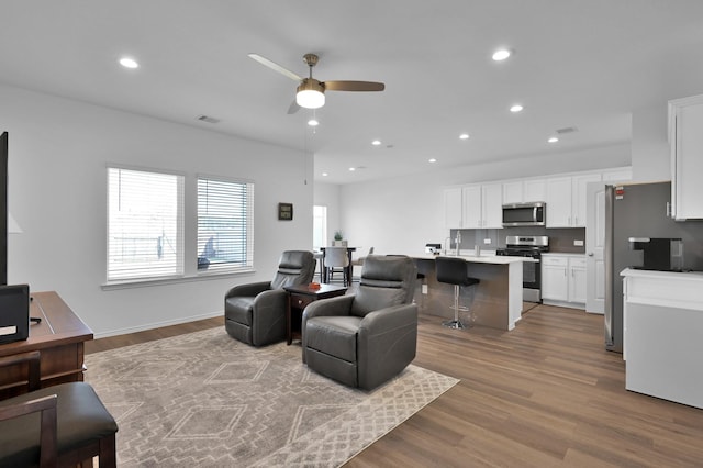 living area featuring recessed lighting, wood finished floors, visible vents, and ceiling fan