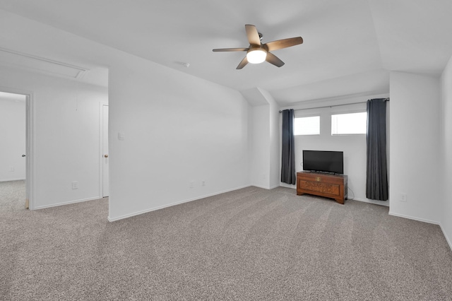 unfurnished living room featuring lofted ceiling, light colored carpet, attic access, and a ceiling fan