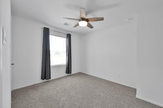 empty room featuring visible vents, baseboards, carpet, and a ceiling fan