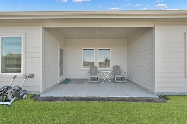 property entrance with a patio area and a yard