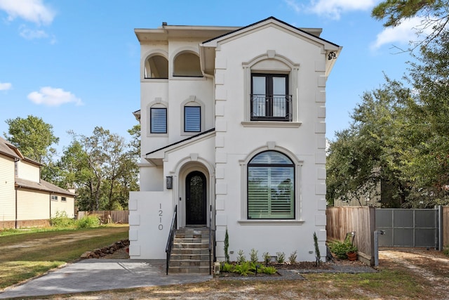 view of front of house with fence and stucco siding