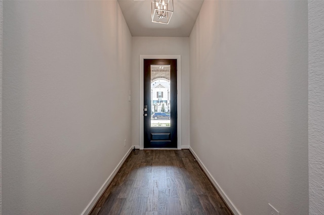 doorway to outside featuring baseboards and dark wood-style flooring