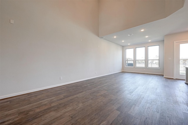 spare room featuring visible vents, recessed lighting, baseboards, and dark wood-style flooring