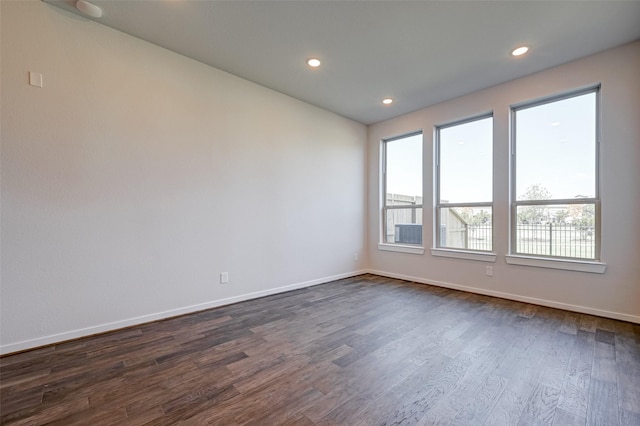 unfurnished room featuring dark wood finished floors, recessed lighting, and baseboards