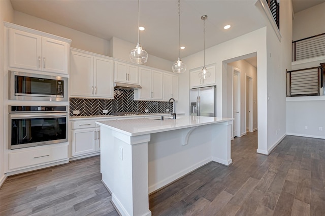 kitchen featuring white cabinets, appliances with stainless steel finishes, light countertops, and a sink