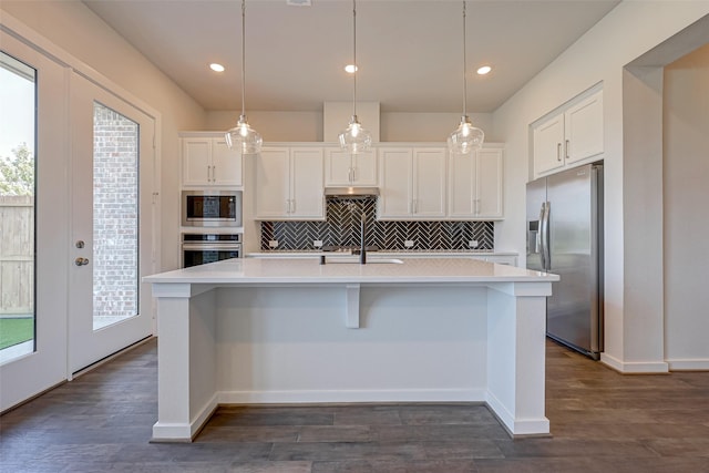 kitchen with dark wood-style floors, white cabinets, stainless steel appliances, and light countertops