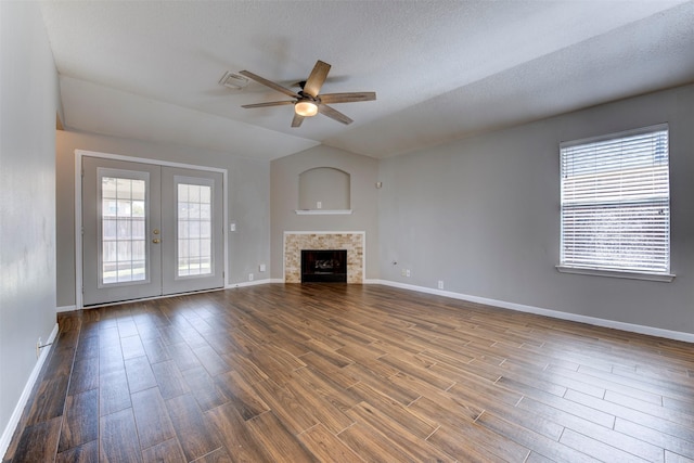 unfurnished living room featuring dark wood-style floors, french doors, baseboards, ceiling fan, and vaulted ceiling