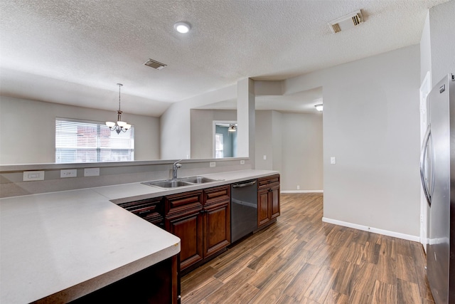 kitchen with wood finished floors, visible vents, a sink, light countertops, and dishwasher