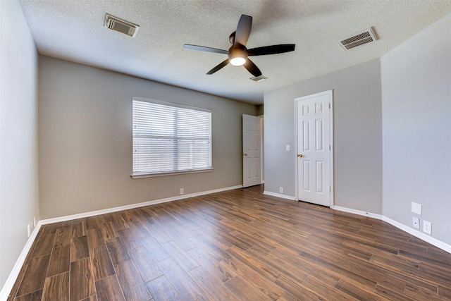 spare room with baseboards, visible vents, dark wood-style flooring, and ceiling fan