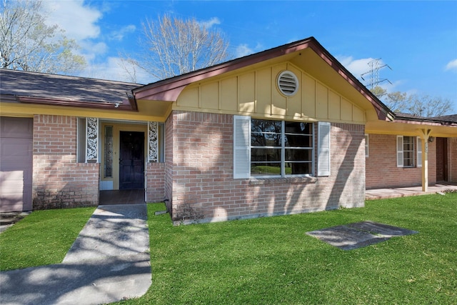 exterior space with board and batten siding, a front lawn, and brick siding