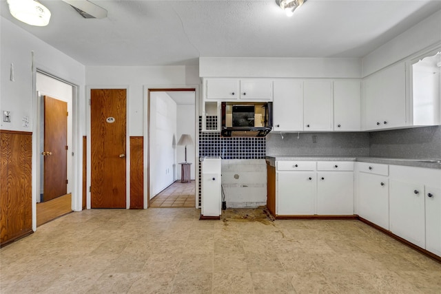 kitchen featuring decorative backsplash and white cabinets