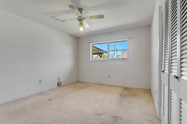 empty room featuring ceiling fan and carpet floors