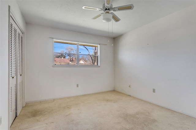 unfurnished bedroom with a ceiling fan, carpet, and a closet