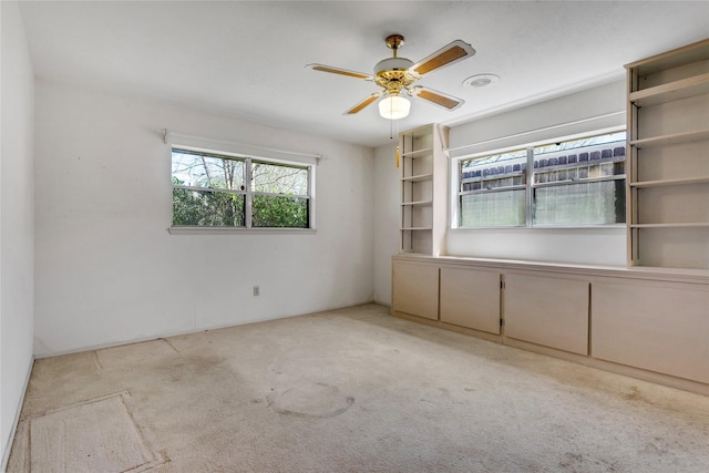 empty room with ceiling fan and carpet