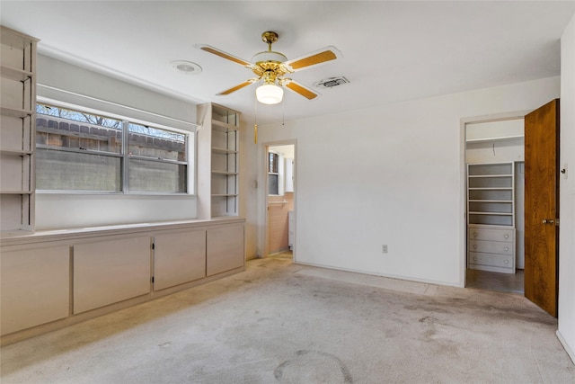 unfurnished bedroom with visible vents, ensuite bathroom, a closet, carpet flooring, and a spacious closet