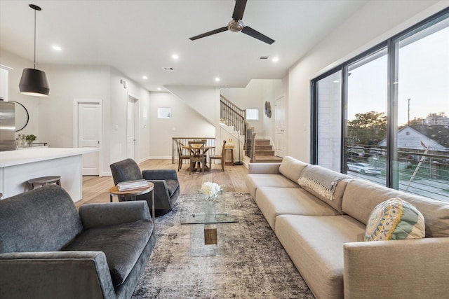 living area with light wood finished floors, stairway, recessed lighting, and a ceiling fan