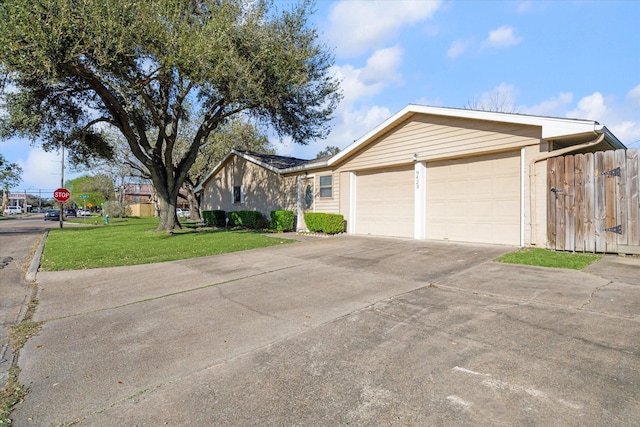 view of front of house featuring an attached garage, concrete driveway, and a front yard