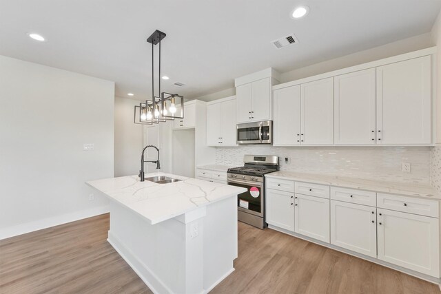 kitchen with a sink, visible vents, light wood-style floors, and appliances with stainless steel finishes