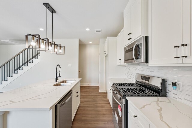 kitchen featuring visible vents, appliances with stainless steel finishes, wood finished floors, white cabinetry, and a sink