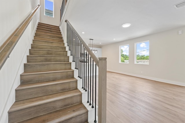 stairway with recessed lighting, wood finished floors, visible vents, and baseboards