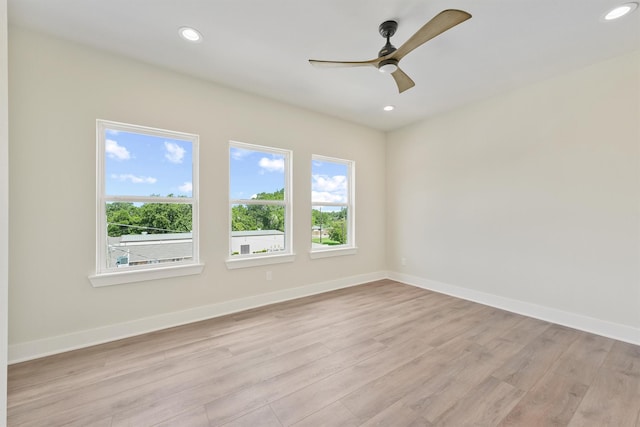 spare room with plenty of natural light, light wood-style floors, and baseboards