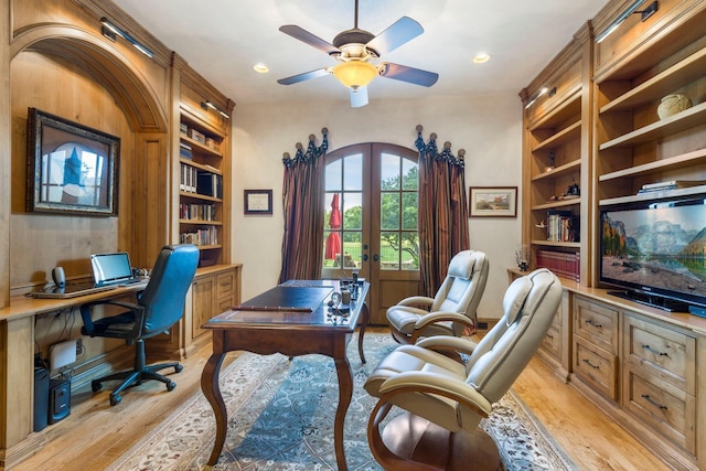 office space with built in features, french doors, light wood-type flooring, and a ceiling fan