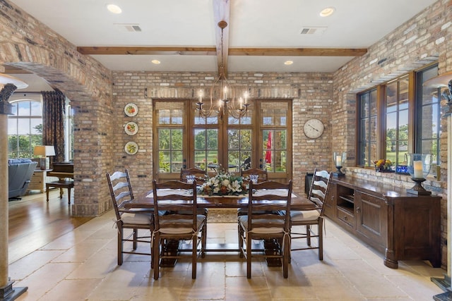 dining space with beam ceiling, stone tile floors, visible vents, and brick wall