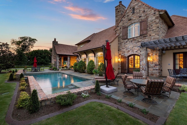 view of pool with a pool with connected hot tub, a pergola, and a patio